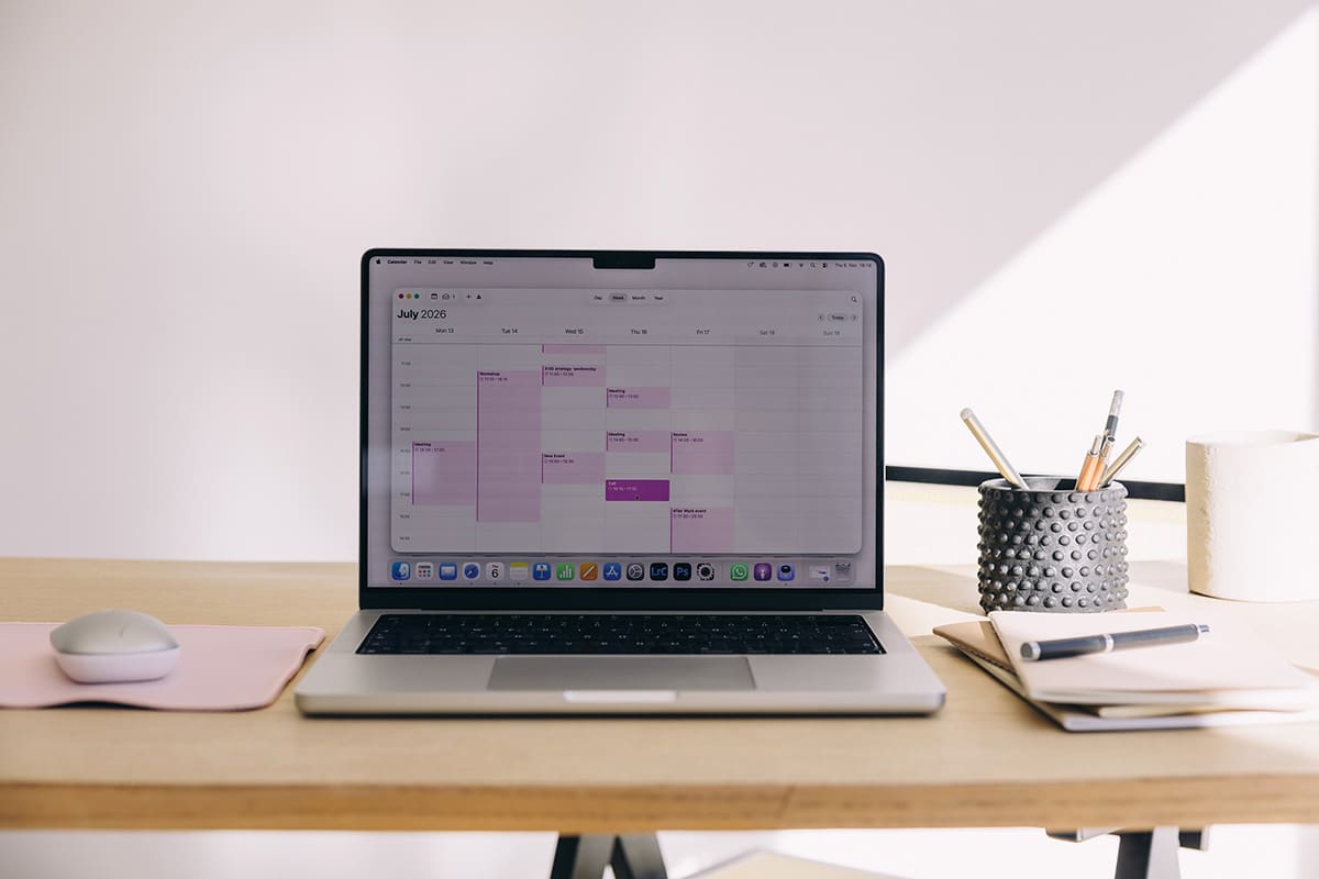 Minimal workspace with laptop displaying calendar, representing website planning, working with H1 tags, and structure helping to show what an H1 tag is.